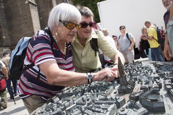 Zwei blinde Menschen tastend am Tastmodell.